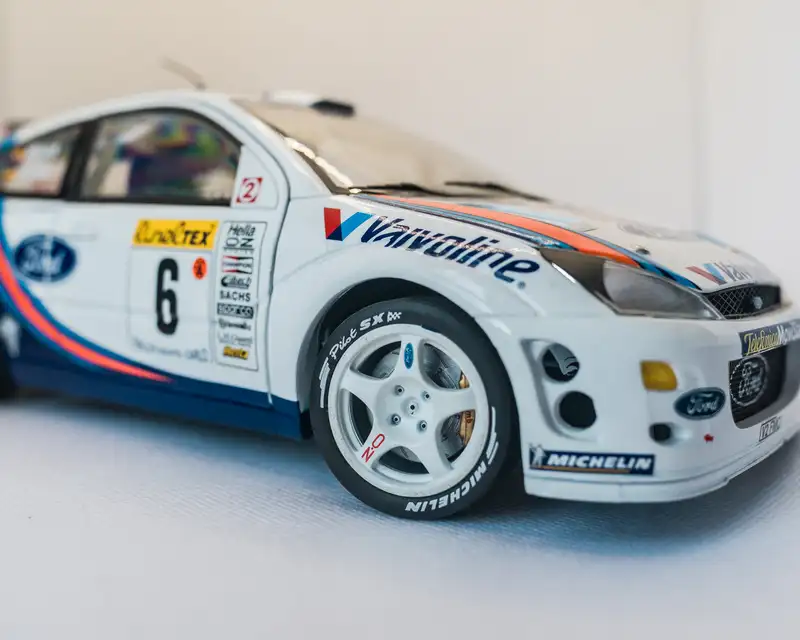 A yellow 1:43 scale 2004 Ford GT from the Ford 100 Years series is displayed in its original packaging in a white studio